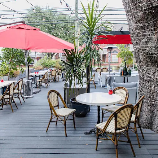 The Ruggles Black patio with red umbrellas and bistro chairs